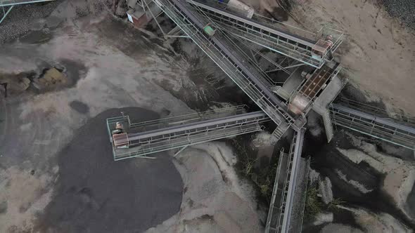 Aerial view basalt quarry of open pit mine machines with sifters and conveyor belts