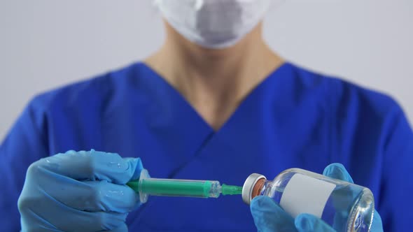 Doctor in Face Mask with Syringe and Medicine