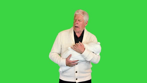 Sleepy and Tired Grandfather Holding Toddler on a Green Screen Chroma Key