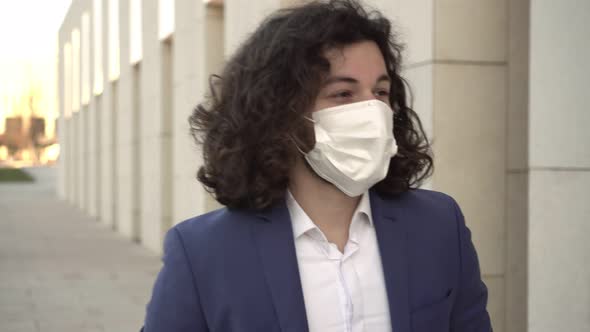 A Man in a Medical Mask Looks at His Watch