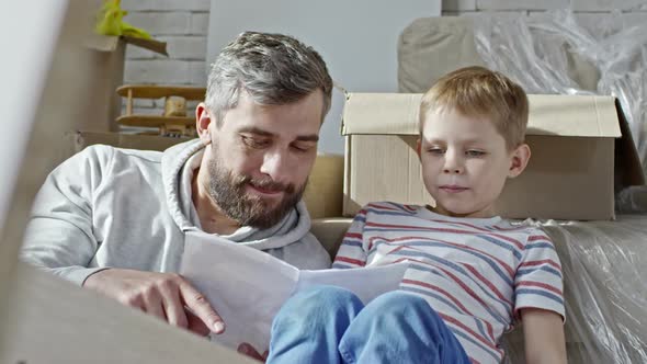 Father and Boy Discussing Assembling Manual