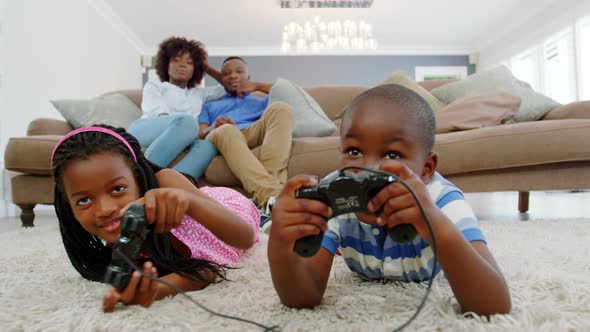 Children playing video game in living room
