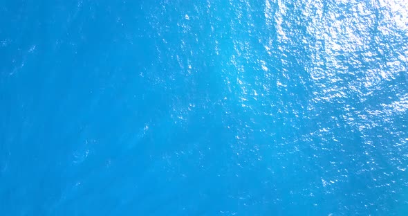 Wide drone abstract view of a white sand paradise beach and blue water background in vibrant 
