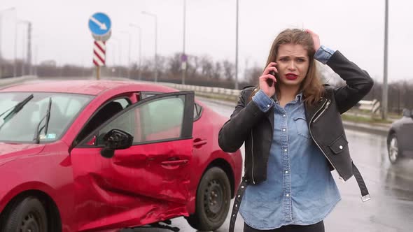 Scared Girl Talking on the Phone After a Car Accident in the Rain, Car Is Broken