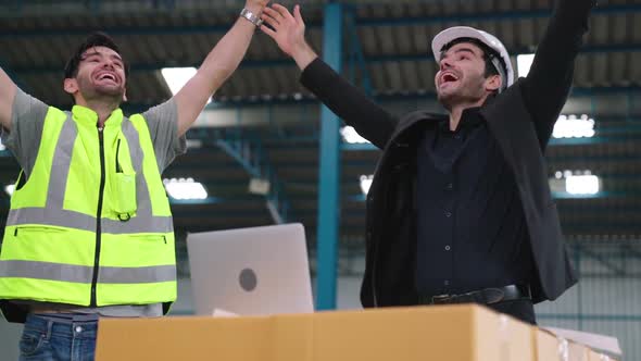 Two Factory Worker Celebrate Success Together in the Factory