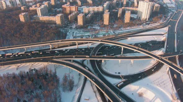 Complex Road Flyover and Junction, Cars Traffic at Sunny Winter Evening in City. Aerial View