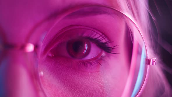 Woman Eye in Pink Neon Light Female Teenager Wearing Glasses Playing Computer Game Looking at Screen