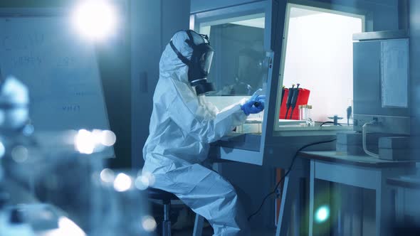 Specialist in a Protection Suit Is Working in a Laboratory Unit. Coronavirus 2019-nCoV Concept.