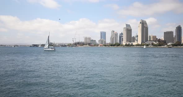 Boats pass by in the ocean with the city of San Diego, California in the background.