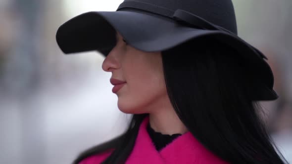 Portrait of a Brunette in a Black Hat and a Pink Coat