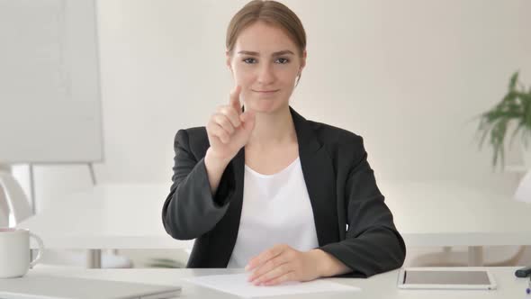 Young Businesswoman Pointing with Finger in Office