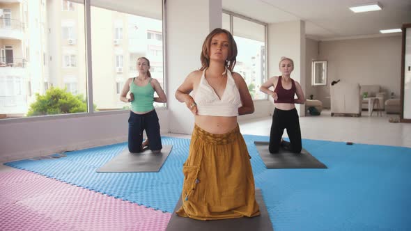 Three Women Having Yoga Classes in the Studio the Younger One Stands in the Front and All of Them