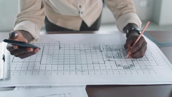 Hands of Afro-American Architect Drawing Floor Plan