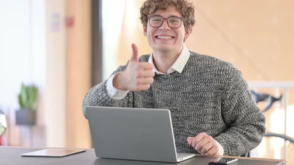 Positive Young Man with Laptop Showing Thumbs Up