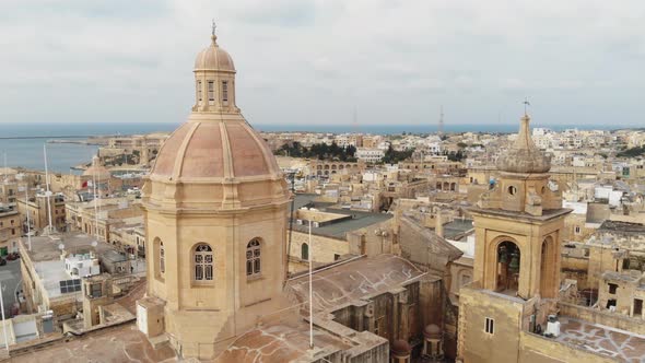 Aerial Close Up Shot of Senglea Basilica Revealing the Port in Malta