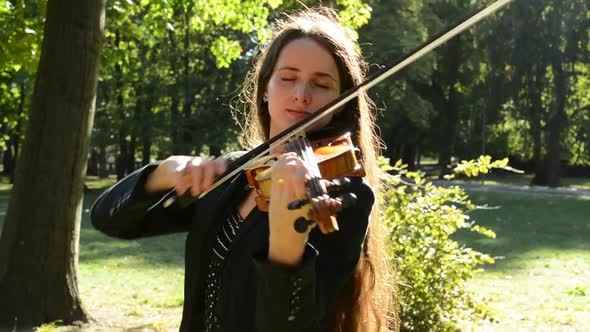 Young Attractive Woman Play on the Violin in the Park - Closed Eyes - Passion
