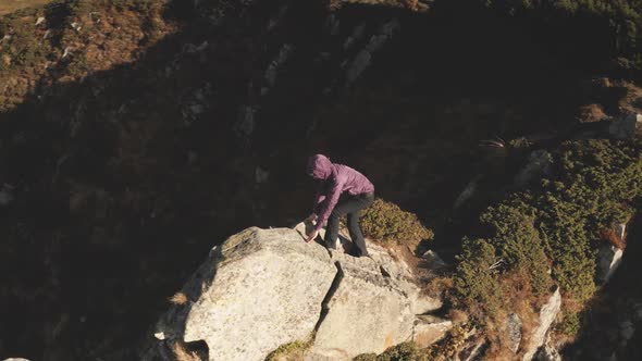 Traveler Girl Climb on Rock Aerial