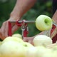 Woman Peeling a Green Apple with an Apple Peeler Outdoors - VideoHive Item for Sale