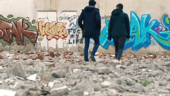 New generation of young people walking in front of graffiti.