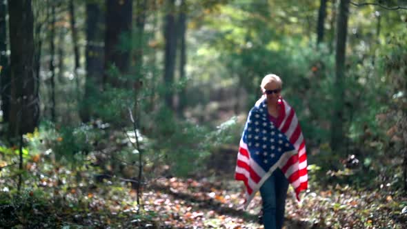 Slow motion of woman with a flag around her is out of focus and then comes into focus as she gets cl