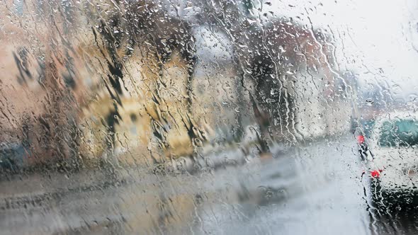 Footage Automobile Road Behind Rain Glass. Raindrops Run Down The Glass, Cars Drive