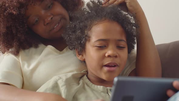 Happy African American Mom and Kid Using Tablet at Home