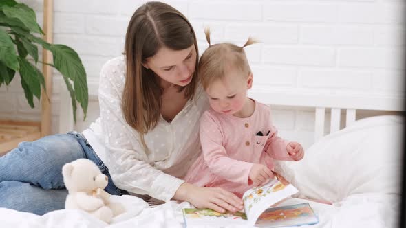 Mother and Baby Sonreading a Book in Bed Before Going to Sleep