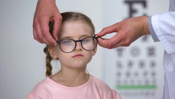 Capricious Little Girl Rejecting Eyeglasses From Optician, Feels Insecure, Shy