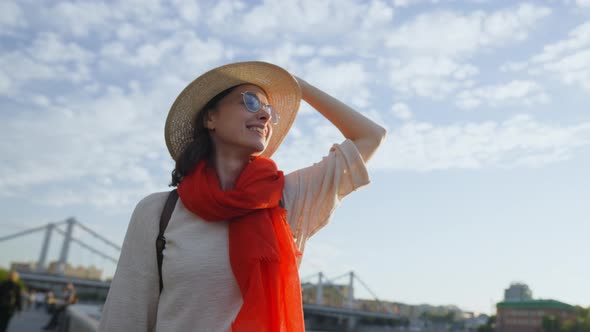 Happy woman in a hat on vacation in summer city