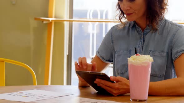 Female executive using digital tablet at table 4k