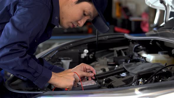 male mechanics check electrical wiring vehicle system in car service
