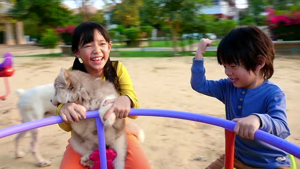 Asian Children And Siberian Husky Puppy Having Fun On Carousel