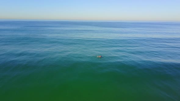 Aerial drone uav view of a SUP stand-up paddleboarder surfing