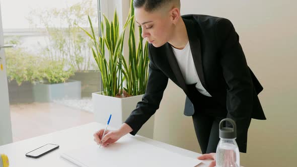 Businesswoman making sketches on paper in office