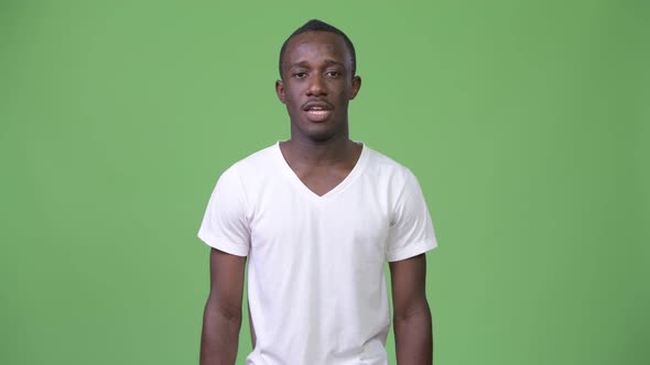 Young Tired African Man Talking Against Green Background