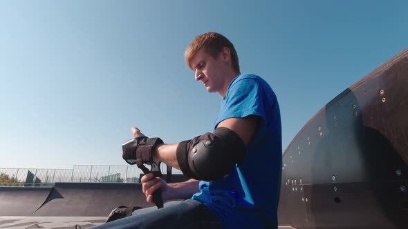 Man In Park Puts On Wrist Protection