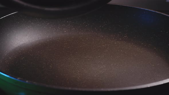 Adding Chicken Breast To A Frying Pan - Close-up View