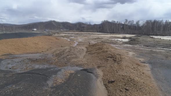 Aerial view of dry riverbed poisoned. Near the road. Cars are driving along the road 28