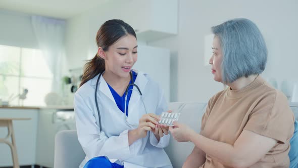 Caregiver pharmacist girl hold medicine pills bottle, explain prescription to elderly older woman.