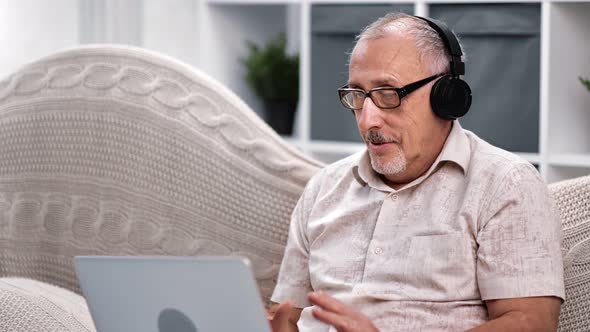 Happy 70s Grandfather Enjoying Conversation Use Laptop