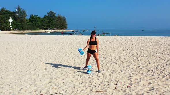 Pretty fun women on photoshoot in the sun at the beach on paradise white sand and blue 4K background