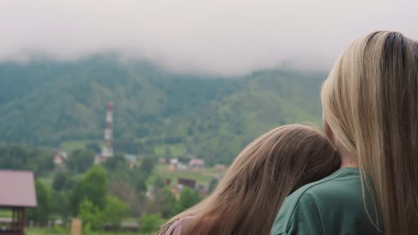 Mother and Little Daughter Look at Misty Distant Mountains