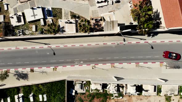 Drone shot above a red cabriolet in the street 4K