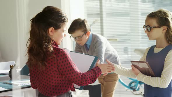 Kids as business executives shaking hands 4k