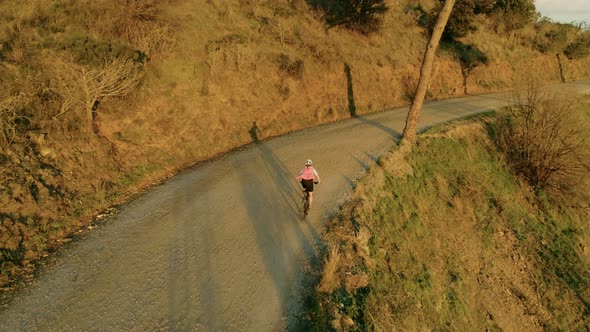 Drone Footage of Woman Cyclist in Sunset on Bike