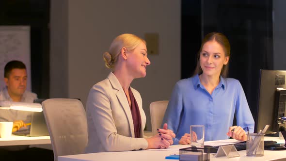 Businesswomen with Computer Working Late at Office 