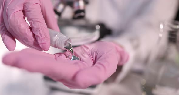 Student Pours Liquid Mercury on Gloved Hand Closeup