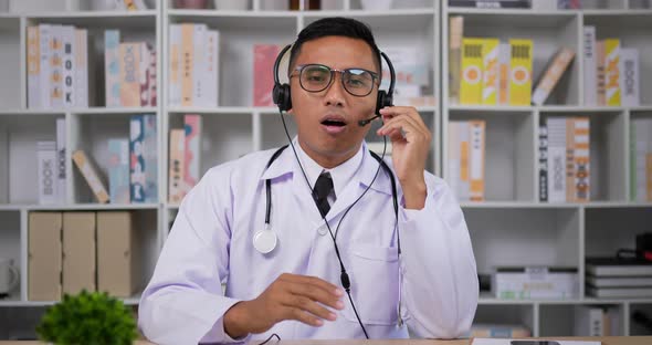 Doctor with headset making conference call and looking at camera