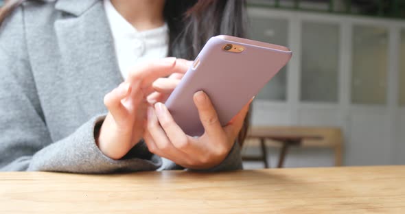 woman using mobile phone in outdoor cafe