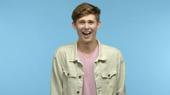 Funny Young Man Laughing and Looking at Camera See Something Hilarious Chuckling at Joke Standing